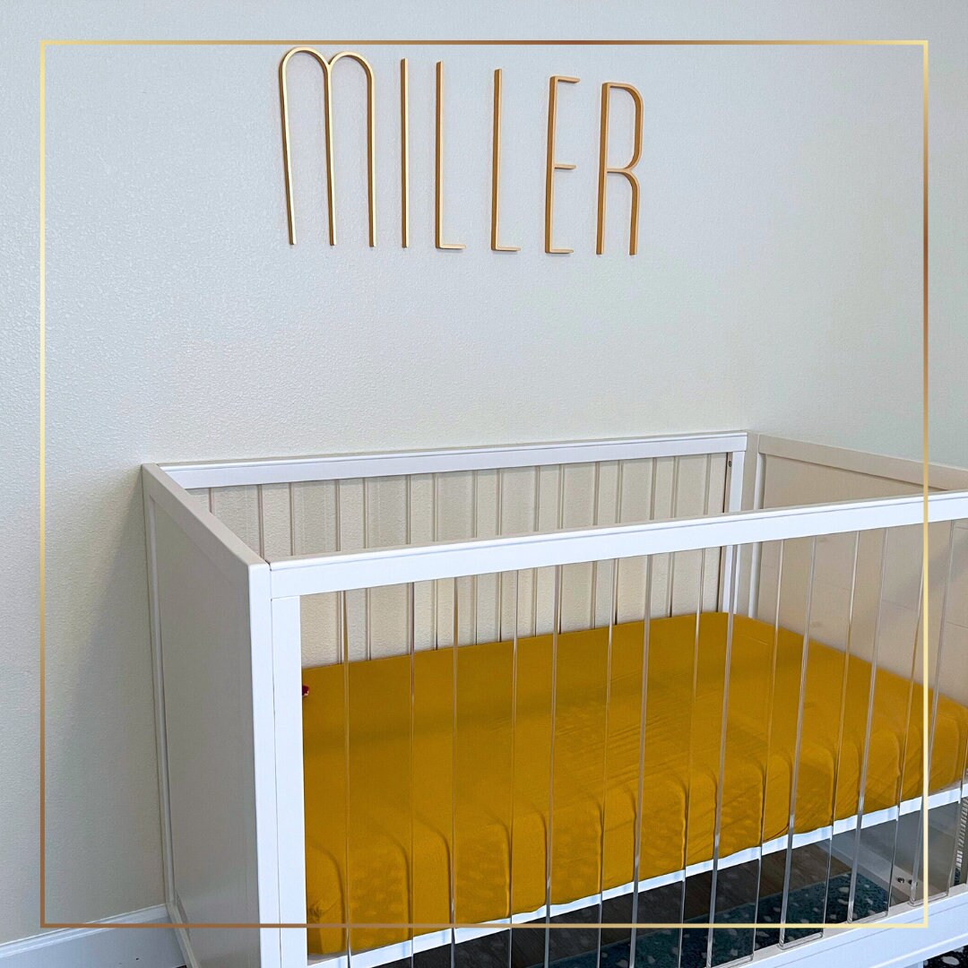 a white crib with a yellow bed in it